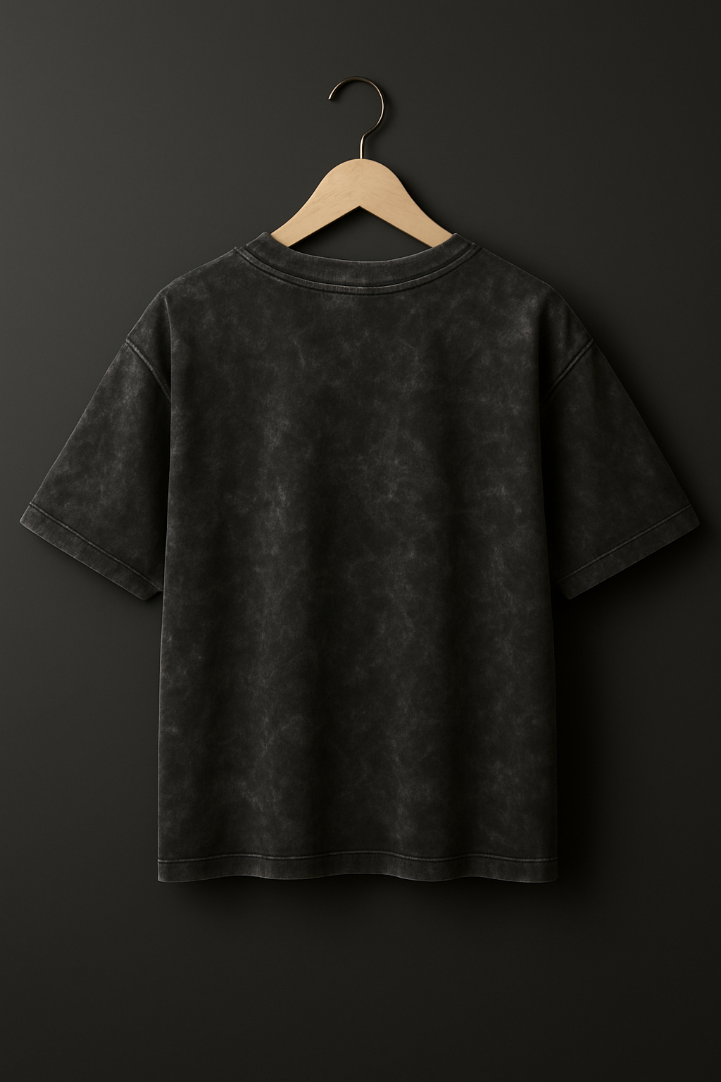 Black t-shirt on a hanger against a dark background