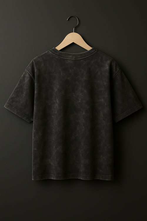 Black t-shirt on a hanger against a dark background